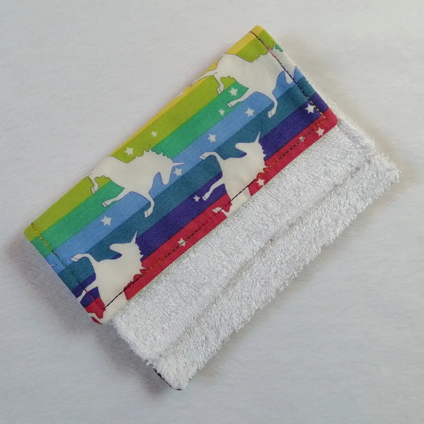 Rainbow striped bamboo cloth with unicorn pattern on a white background