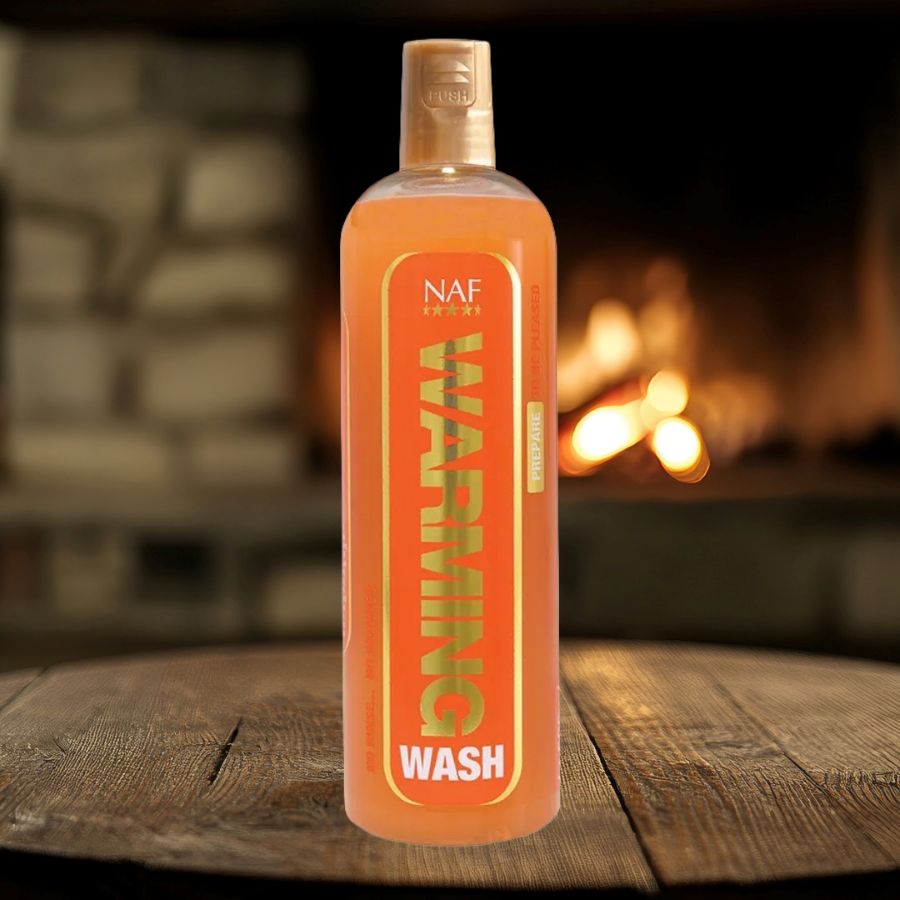 Bottle of NAF Warming Wash on a wooden surface with a fireplace in the background