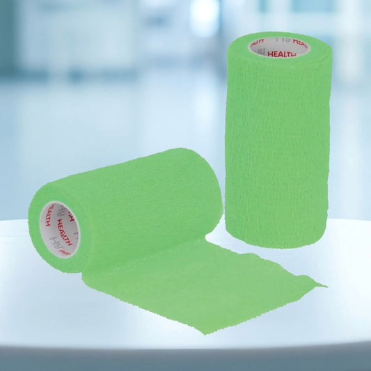 Two rolls of green cohesive bandage on a white surface with a blurred blue background