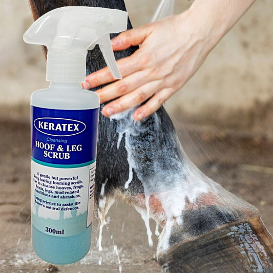 Keratex Hoof & Leg Scrub being used on a horse's leg with a hand holding the spray bottle.