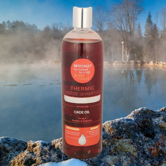Bottle of Thermic Horse Shampoo on a rocky surface with a lake and trees in the background