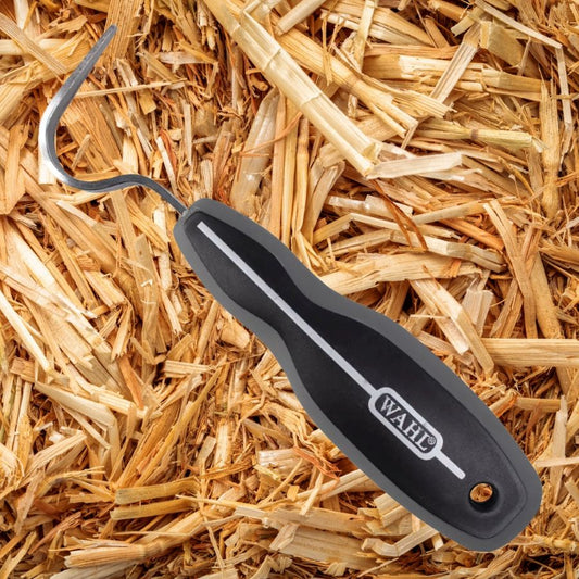 Black Wahl hoof pick for horses on a bed of straw